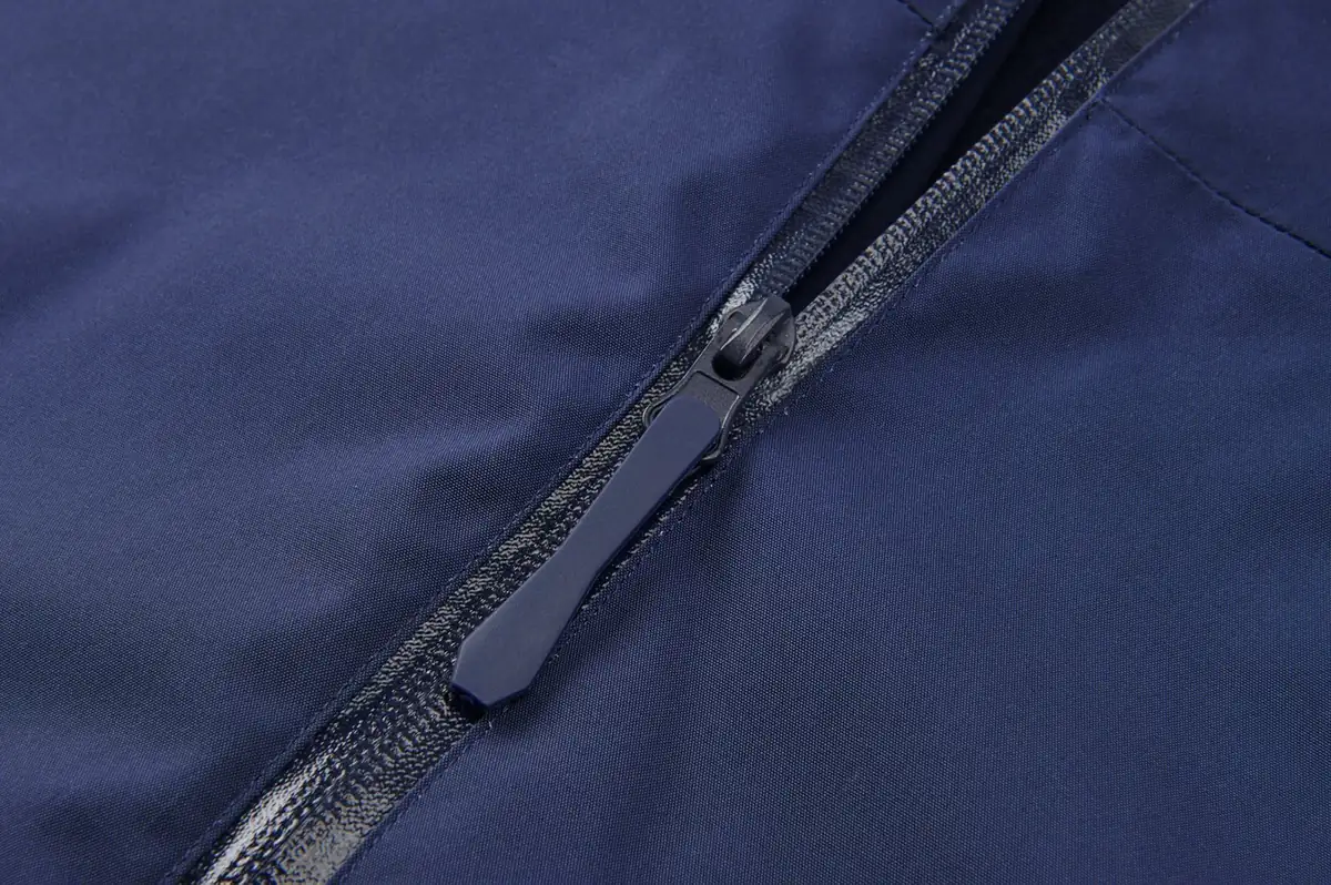 Close-up of a waterproof zipper on a navy technical shell jacket made by PTOUTWEAR