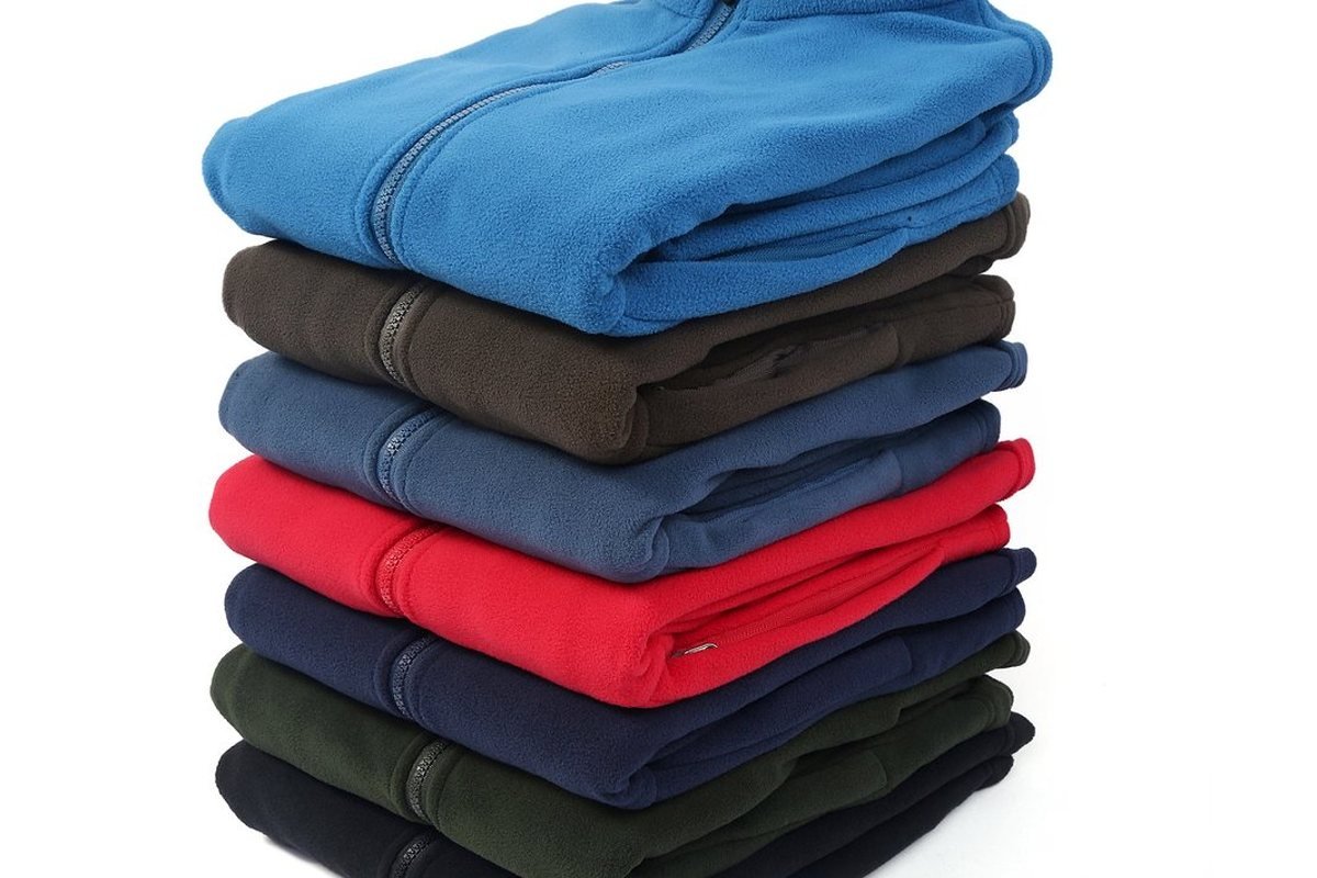 Production run of fleece jackets stacked by colour - Custom Jacket Tech Pack Guide: Complete Spec Sheet Walkthrough