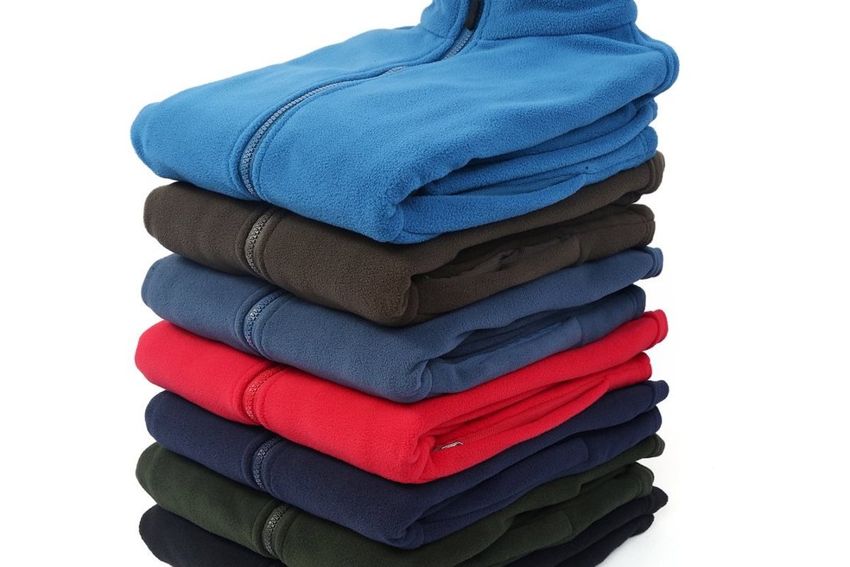 Production run of fleece jackets stacked by colour - How Much Does It Cost to Manufacture Custom Softshell Jackets in China?