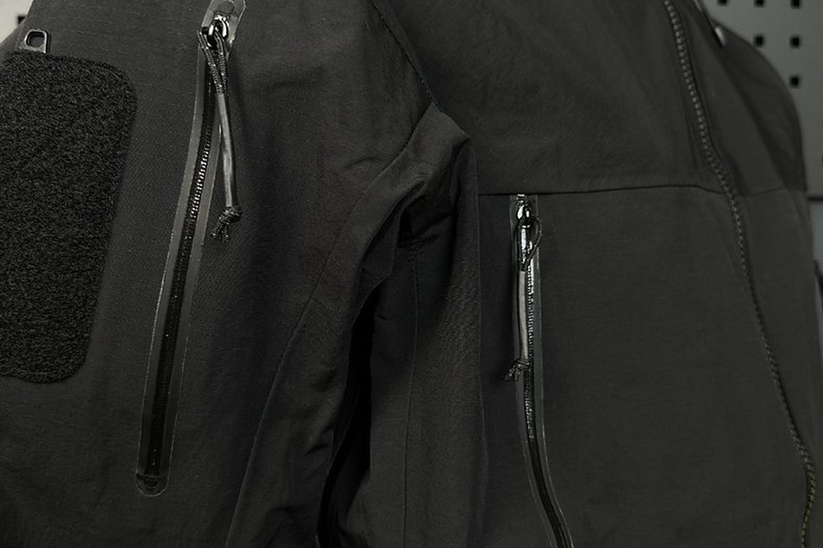 Hook-and-loop panels and zip pockets on a black tactical softshell - How to Choose a Dropship Ski Snowboard Brand Supplier (2