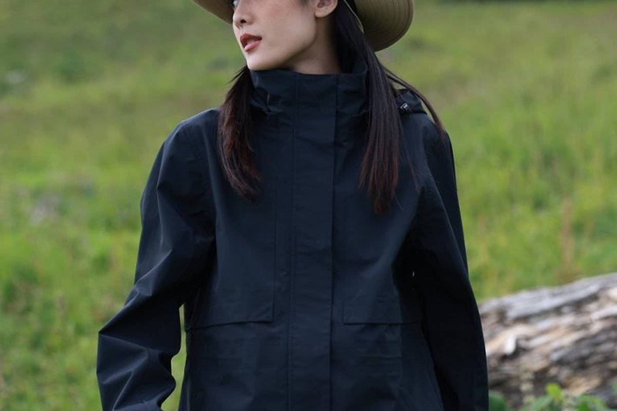 Hiker in a navy hardshell jacket on a hillside - How to Choose an Outdoor Jacket: 2026 Technical Guide