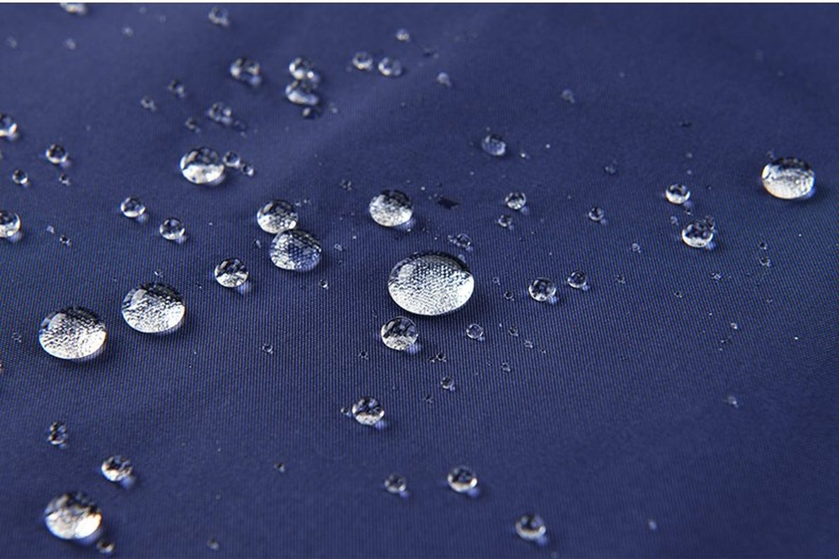 Water beading on the DWR-treated face of a navy shell fabric - OEM Waterproof Jacket Branded Trims Packaging Budget Guide